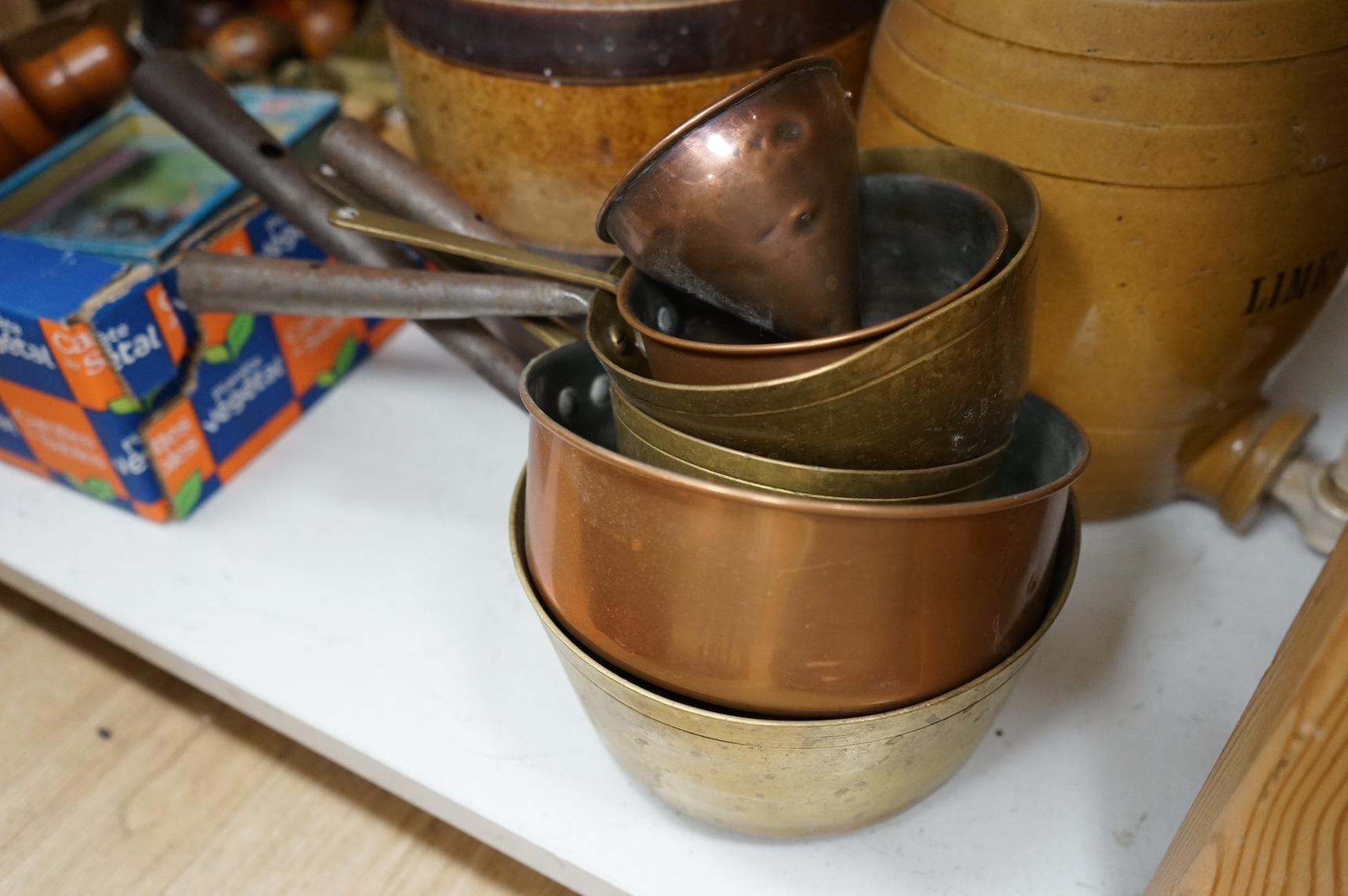 Four Victorian stoneware flagons / jars, five copper/brass saucepans and a funnel, largest 33cm high